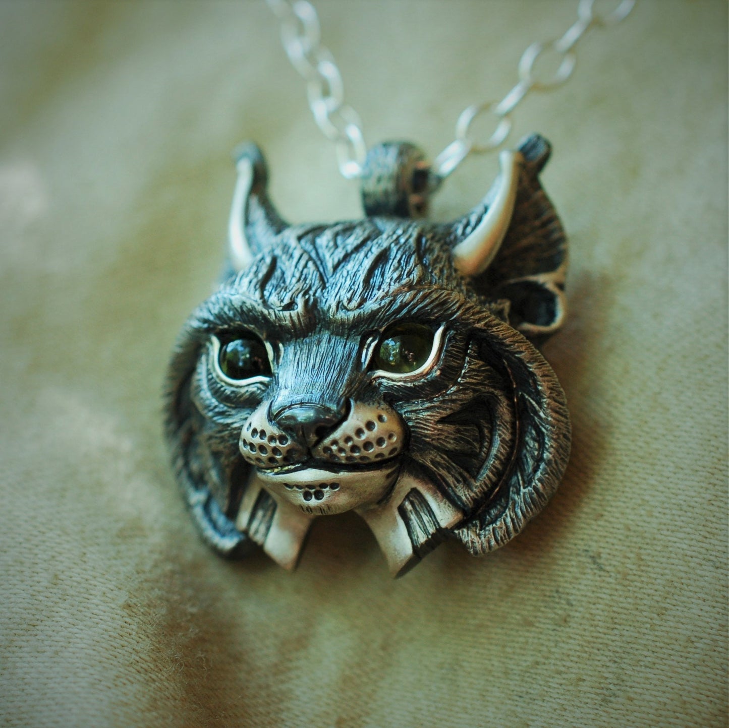 Large Lynx Necklace. Sterling silver lynx head pendant with peridot eyes and a silver chain. Handmade to order. © Adrian Ashley