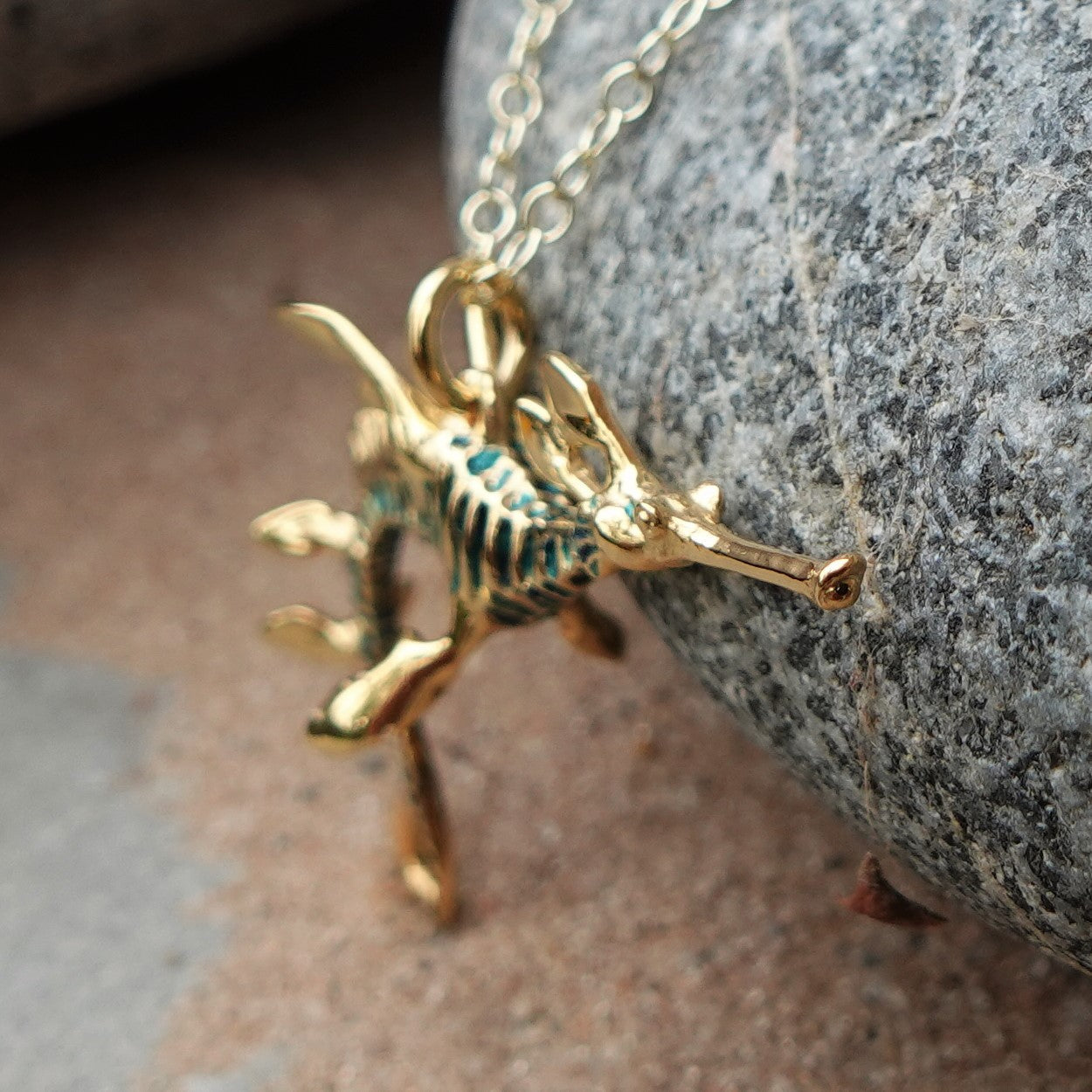 Gold sea dragon necklace, 3D weedy seadragon pendant with a blue patina and a gold chain. Handmade to order. © Adrian Ashley