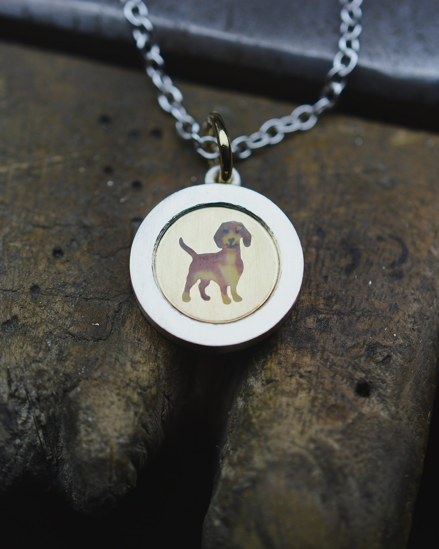 Enamel Dachshund on an 18ct gold disk in a silver pendant mount