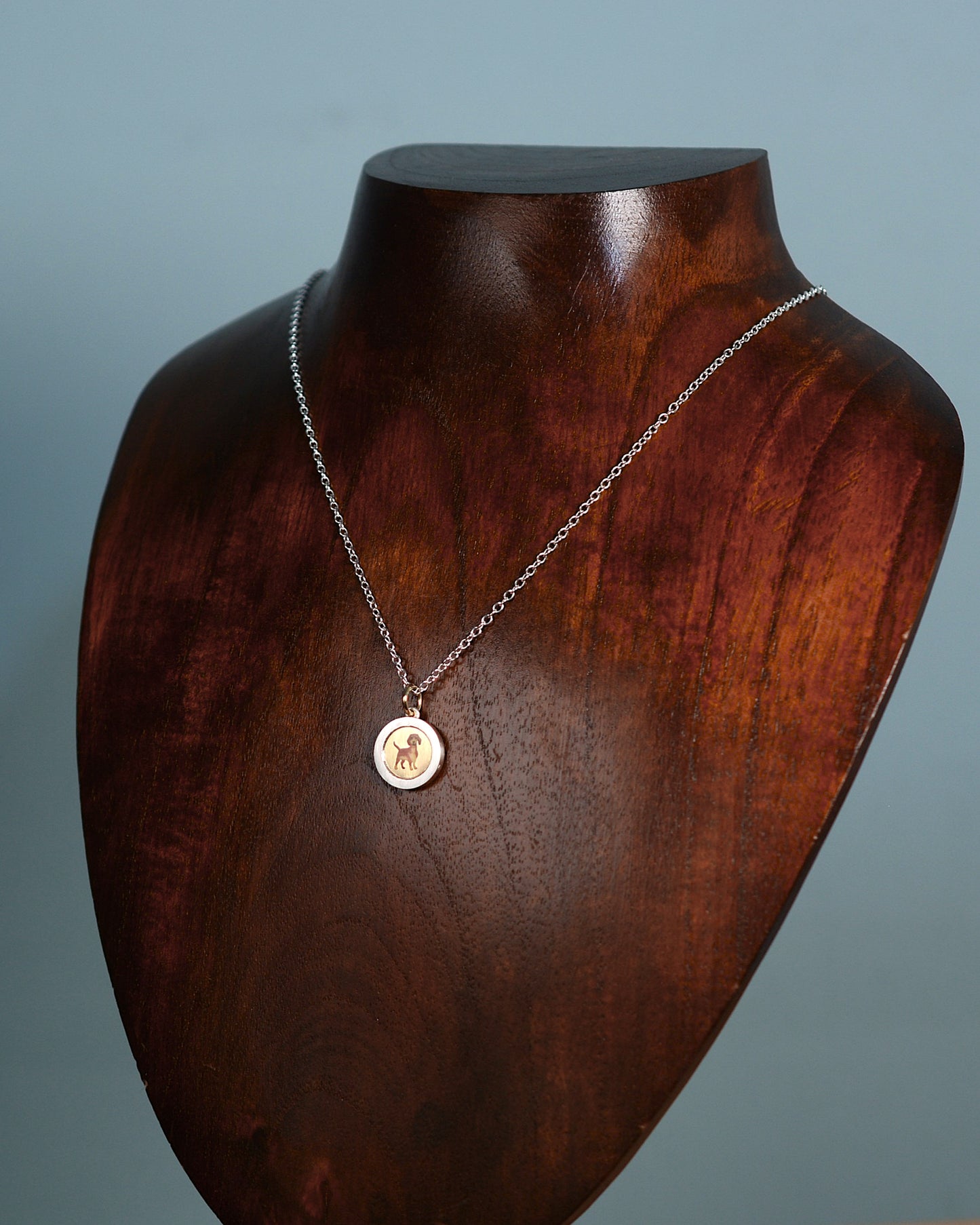 Enamel Dachshund on an 18ct gold disk in a silver pendant mount