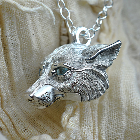 White Wolf Necklace. Sterling silver wolf's head pendant with blue topaz eyes and a silver chain. Ready to be shipped. © Adrian Ashley