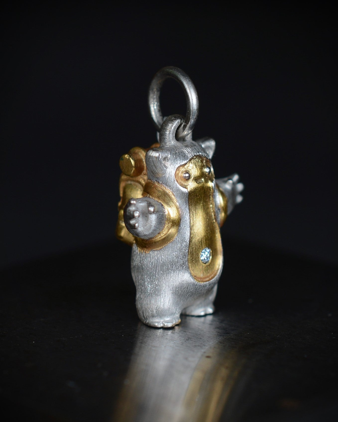 Fox eared, pear shaped, backpacker Bright Creature with a diamond and parcel gilt.