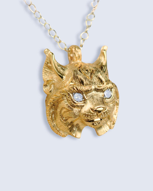 Gold lynx head pendant with diamond eyes and a gold chain.