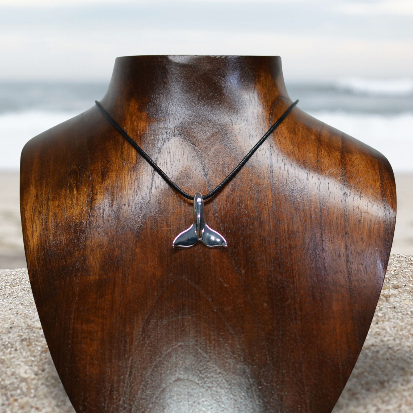 Classic whale tail necklace. Made from highly polished, tarnish resistant silver, strung on a strong cord. © Adrian Ashley