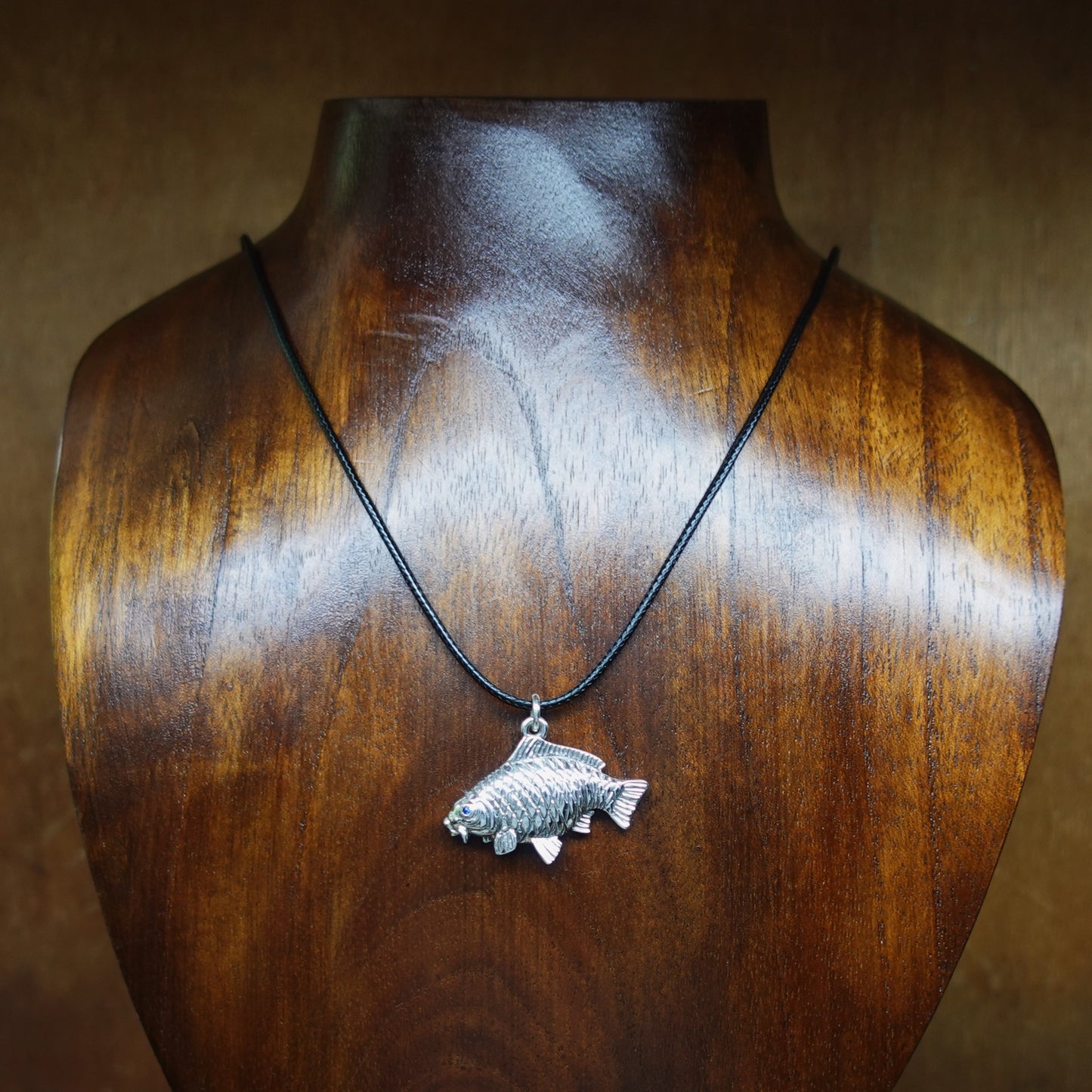 Common Carp fishing necklace. Made from sterling silver with an antiqued finish, set with a gemstone eye. Ideal fisherman’s angling gift © Adrian Ashley