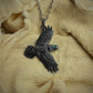 Raven necklace, double sided silver and emerald pendant with a black finish and a silver chain. © Adrian Ashley