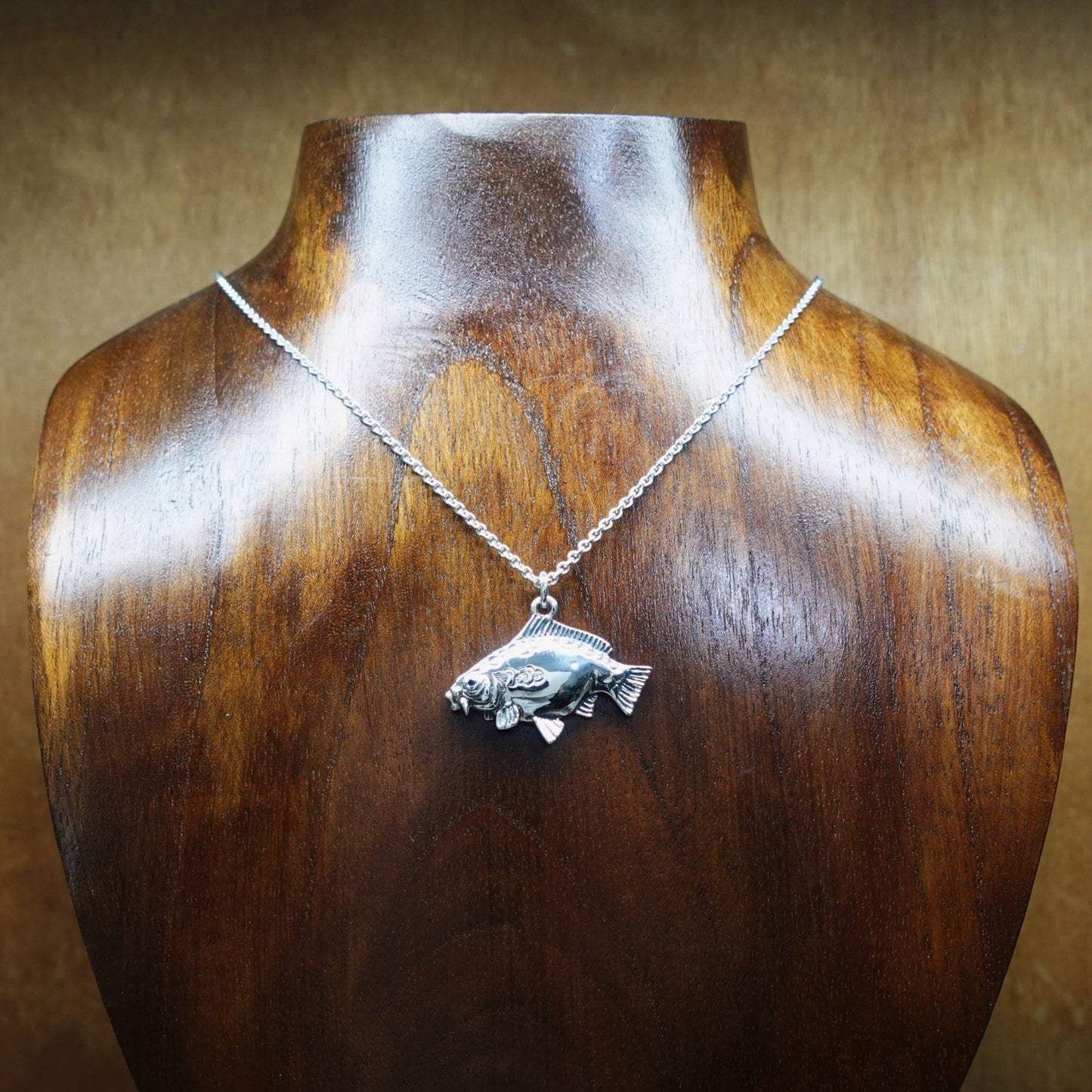 Mirror Carp fishing necklace. Made from sterling silver with an antiqued finish, set with a gemstone eye. Ideal fisherman’s angling gift © Adrian Ashley