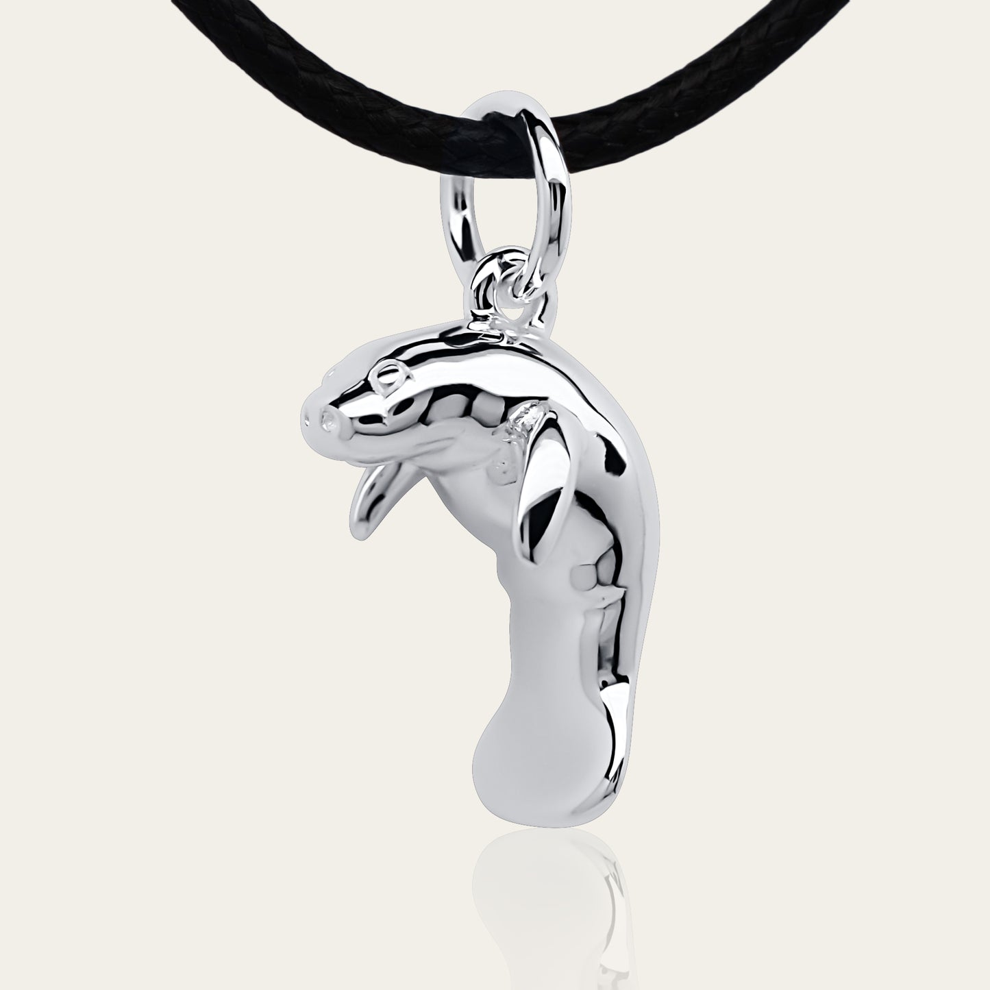 Manatee charm necklace. Made from highly polished, tarnish resistant silver, strung on a strong cord. © Adrian Ashley