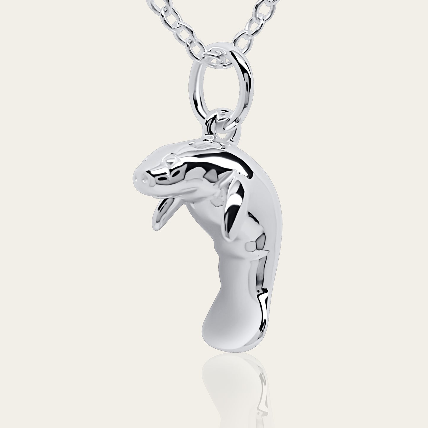 Manatee charm necklace. Made from highly polished, tarnish resistant silver, hung on a solid silver chain. © Adrian Ashley