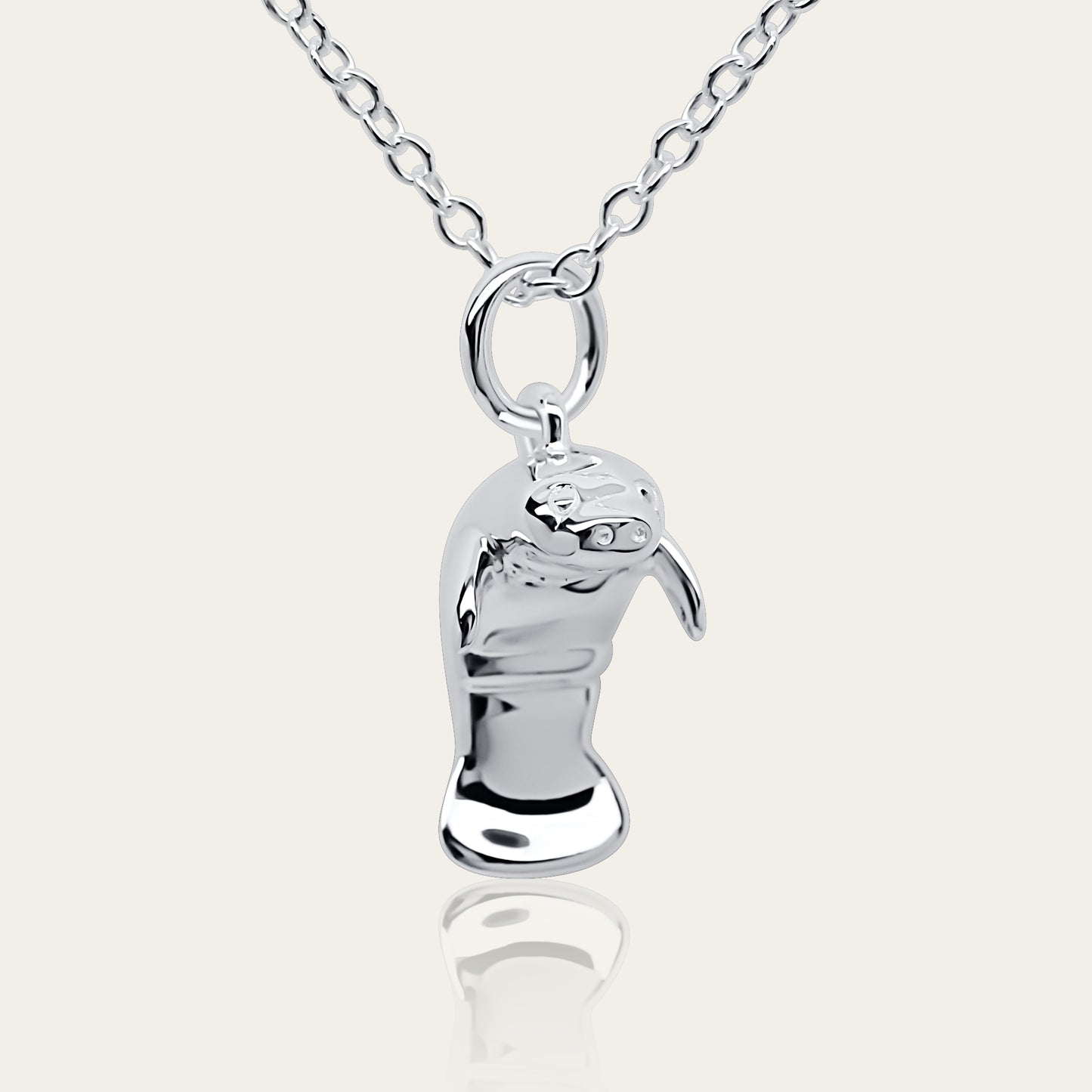 Manatee charm necklace. Made from highly polished, tarnish resistant silver, hung on a solid silver chain. © Adrian Ashley