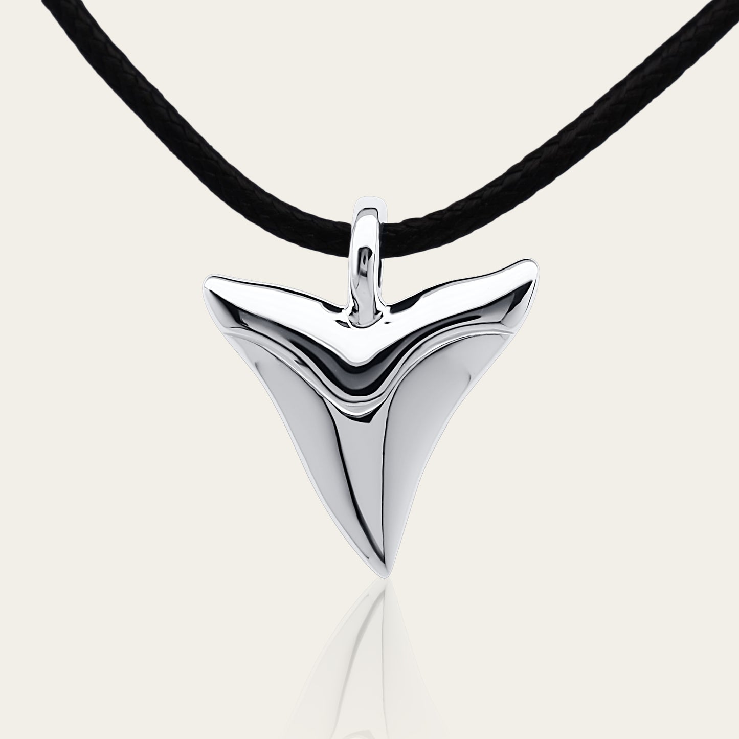 Shark tooth necklace. Classic shark's tooth charm made from highly polished, tarnish resistant silver, strung on a strong cord. © Adrian Ashley