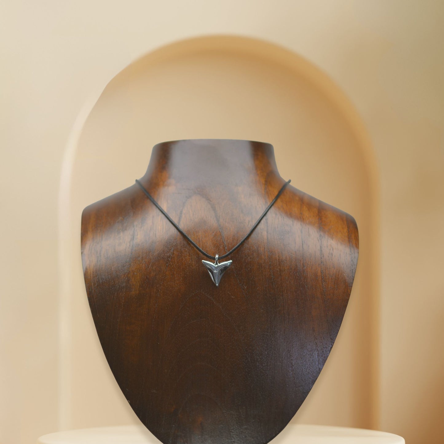 Shark tooth necklace. Classic shark's tooth charm made from highly polished, tarnish resistant silver, strung on a strong cord. © Adrian Ashley