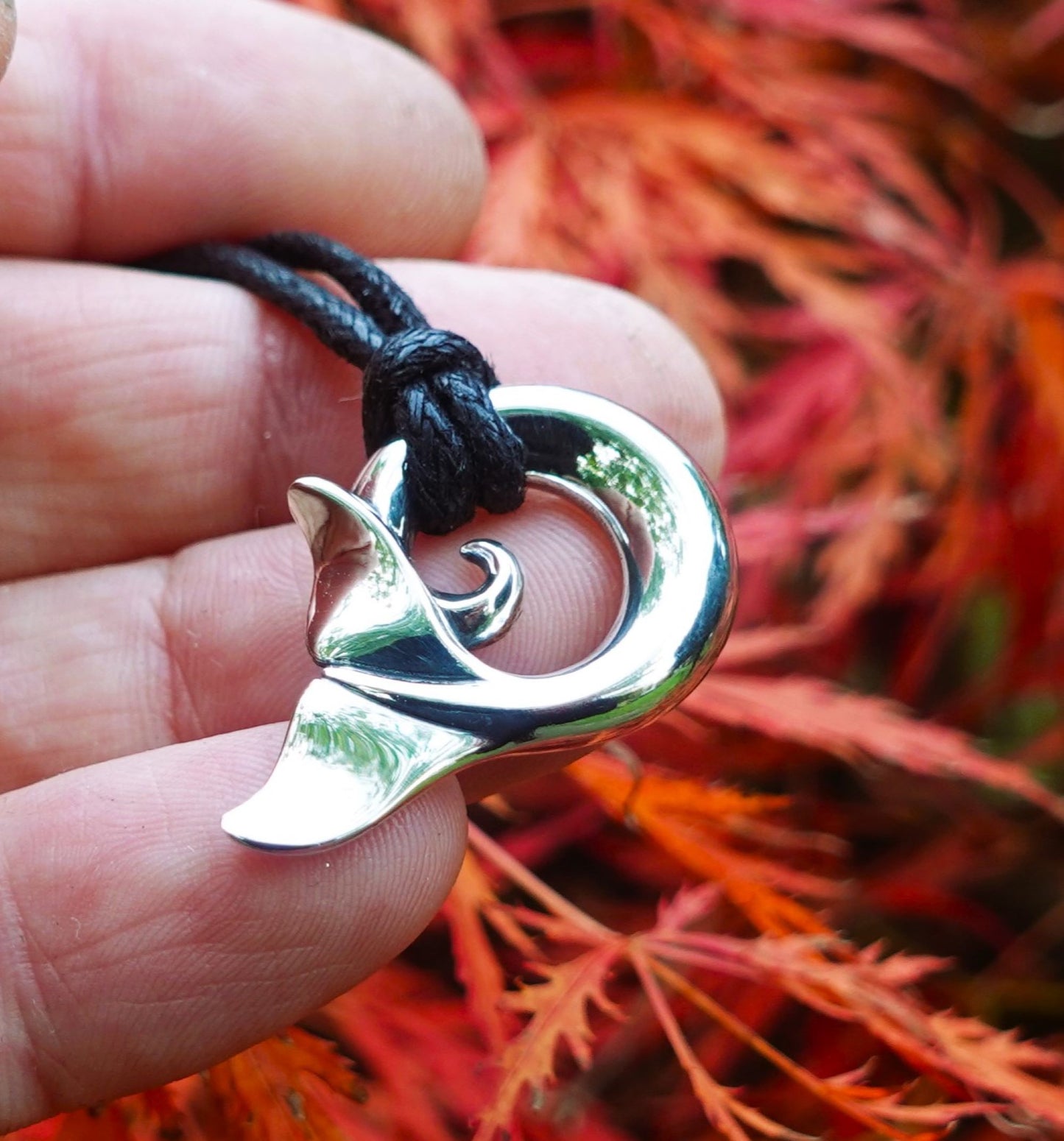 Whale spirit necklace. Made from highly polished, tarnish resistant silver, strung on a strong cord. © Adrian Ashley