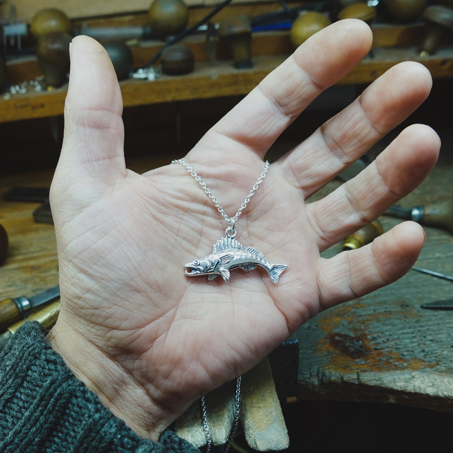 Zander fishing necklace. Made from sterling silver with an antiqued finish, set with a gemstone eye. Walleye pendant, ideal fisherman’s angling gift © Adrian Ashley