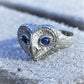 Silver and sapphire owl ring, platinum plated sterling silver barn owl with sapphire eyes. © Adrian Ashley