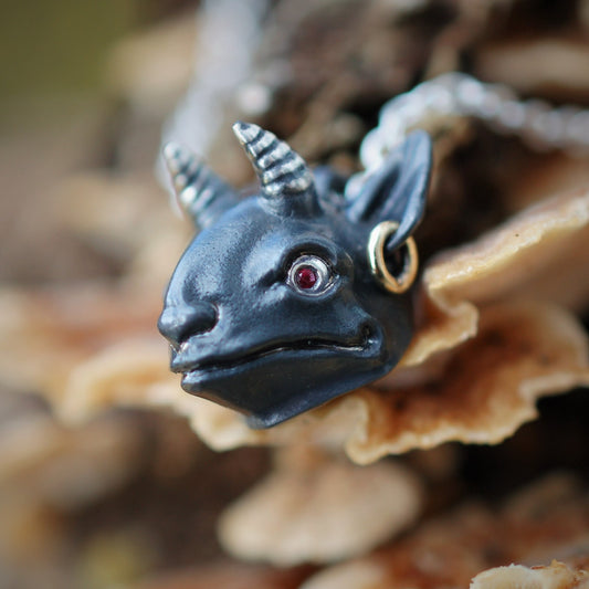 Imp head necklace. Oxidised sterling silver demon pendant with ruby eyes and a solid gold earring, on a strong silver chain. © Adrian Ashley