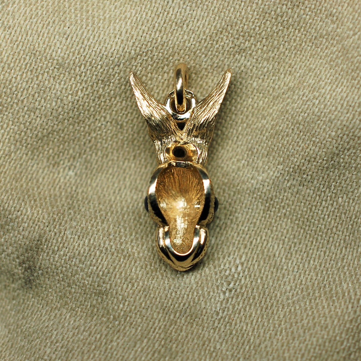 Gold rabbit necklace. Gold hare pendant with dark sapphire eyes and a gold chain. Hand made to order in the UK. © Adrian Ashley