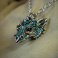Silver dragon's head necklace. Sterling silver dragon pendant, with blue topaz eyes and a solid silver chain. Made to order. © Adrian Ashley