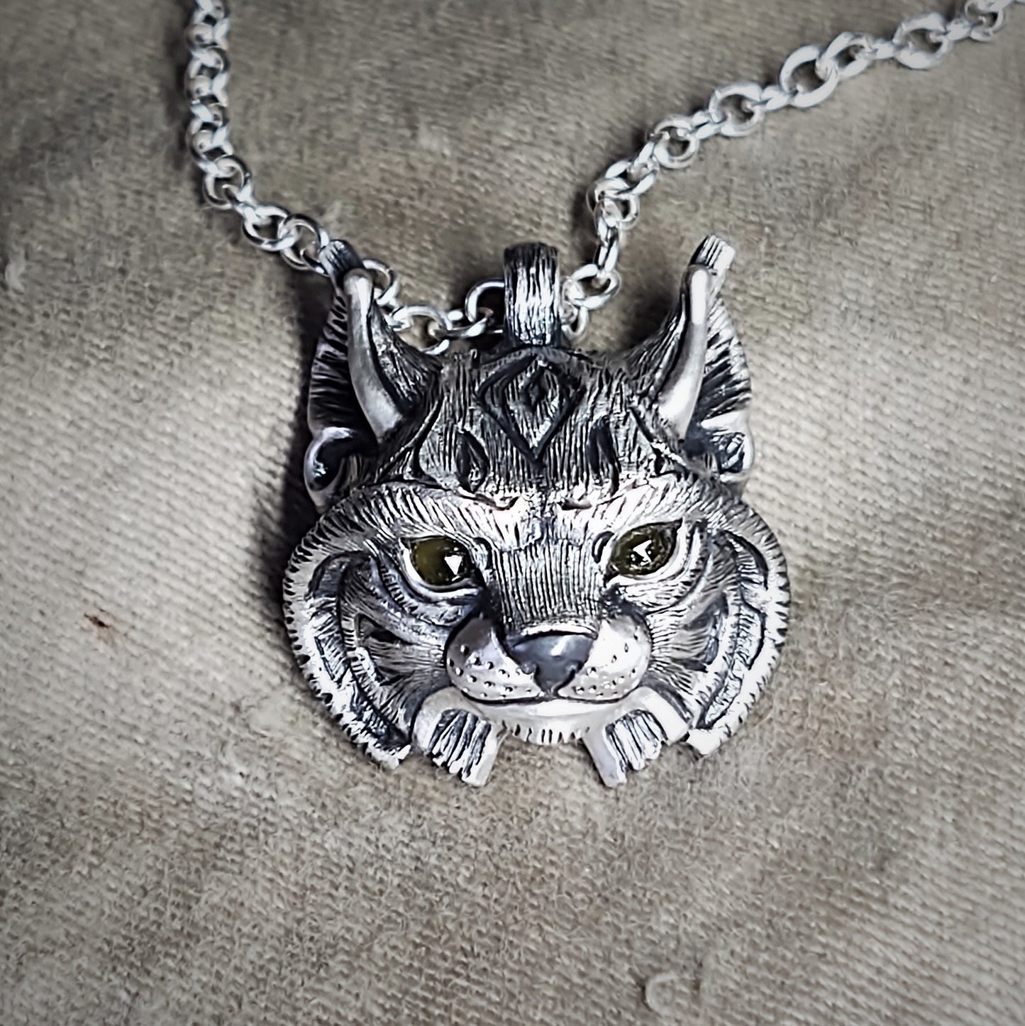 Mid-size Lynx Necklace. Sterling silver lynx's head pendant with natural gemstone eyes and a solid silver chain. Hand made to order. © Adrian Ashley