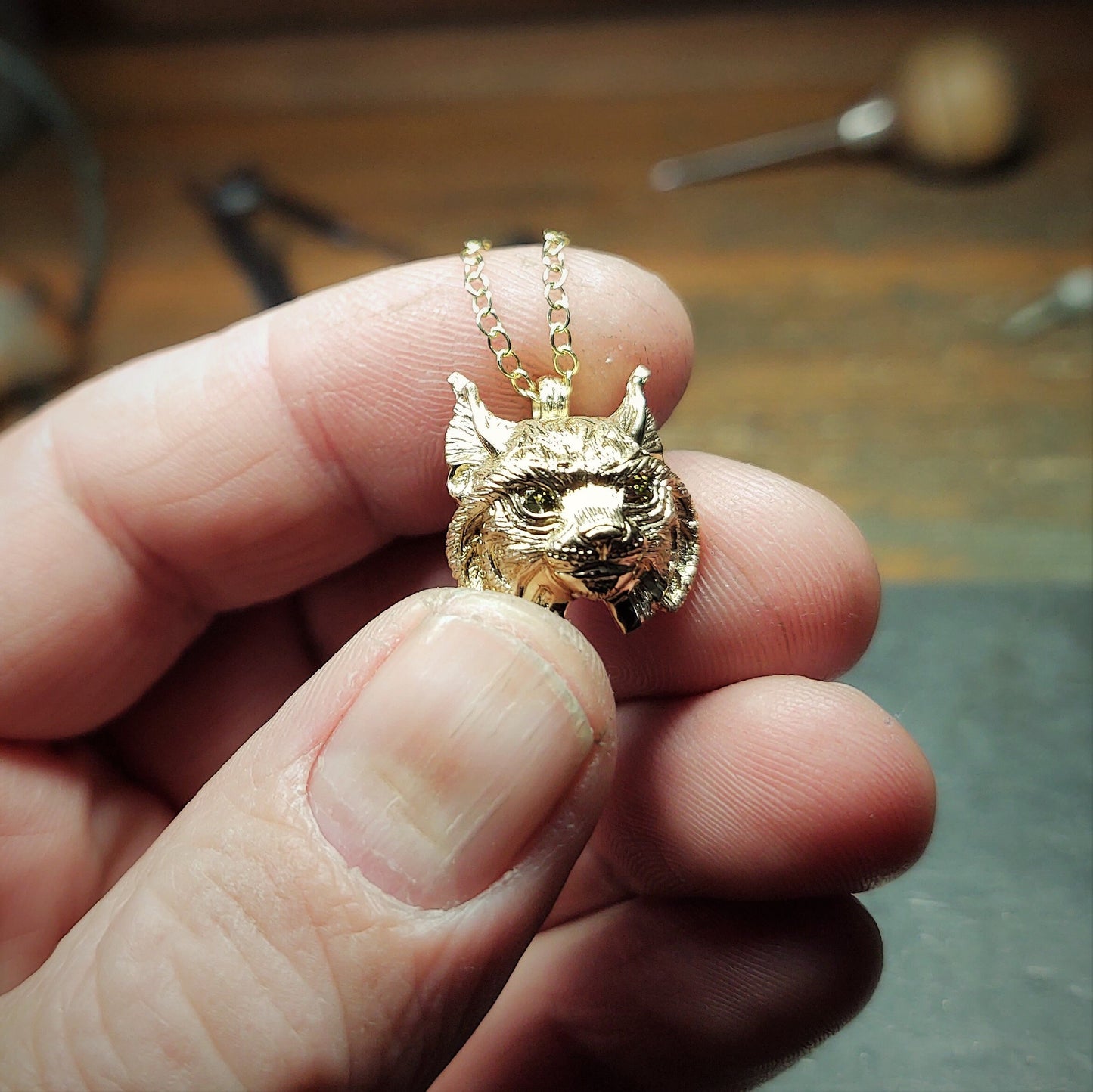 Gold lynx head pendant with diamond eyes and a gold chain. Hand made to order. © Adrian Ashley